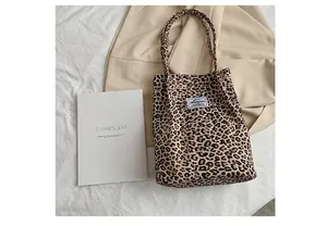 Vue détaillée d'un sac cabas à imprimé léopard avec étiquette Augur sur un fond de tissu blanc