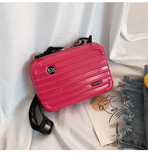 Detailansicht einer pinken Mini-Koffer Umhängetasche mit einem breiten LOVE-Gurt