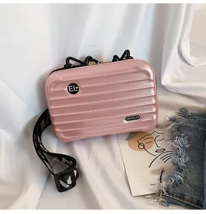 Detailansicht der pinkfarbenen Mini-Koffer-Umhängetasche mit gewebtem Riemen
