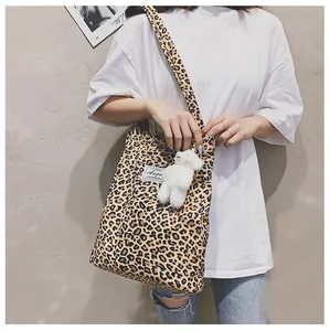 Sac à bandoulière léopard élégant avec un adorable pendentif en peluche mouton blanc