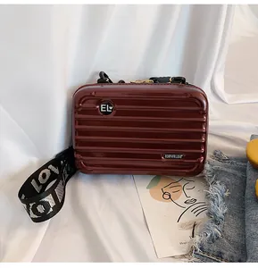 Elegante weinrote Mini-Koffer-Tasche mit glänzendem Rillendesign und breitem Schultergurt.