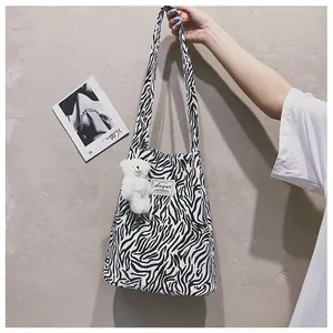 Sac à bandoulière zébré élégant avec un adorable petit ours en peluche blanc.