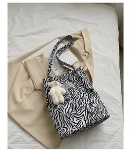 Gros plan d'un sac cabas en toile à motif zèbre avec un charmant ours en peluche.