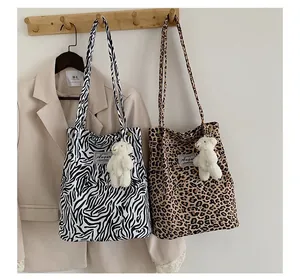 Vue détaillée des sacs fourre-tout à imprimé zèbre et léopard avec des oursons en peluche