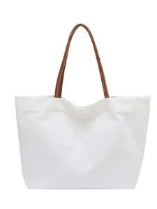Stylish white minimalist canvas tote bag featuring high-quality brown leather handles