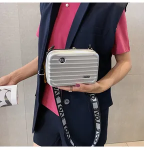 Nahaufnahme einer silbernen Mini-Koffer-Umhängetasche mit geripptem Design