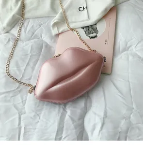 Dettaglio di una mini borsa a tracolla rosa lucida a forma di labbra con catena.