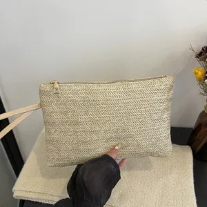 Close-up of the textured herringbone weave on this minimalist cream straw clutch bag.