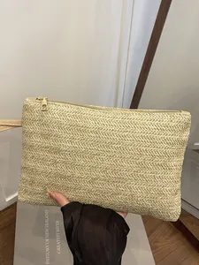 Minimalist woven straw clutch bag with wristlet for beach vacation