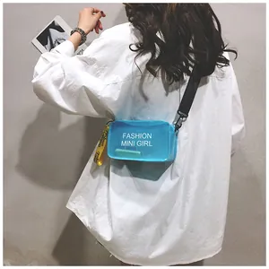 Vista trasera de una modelo con un bolso bandolera de gelatina azul transparente y camisa blanca