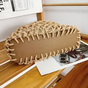 Close-up detail of handmade woven cotton rope handbag featuring a sturdy brown leather base