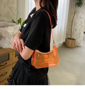 Vibrant orange transparent jelly shoulder bag for women shown worn as a stylish underarm bag