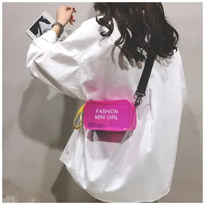 Modelo con bolso bandolera de gelatina rosa transparente sobre una camisa blanca
