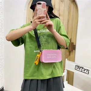Bolso bandolera de gelatina rosa transparente con estampado 'Fashion Mini Girl' en modelo.
