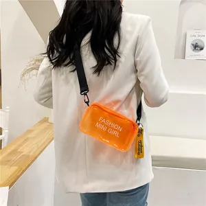 Detalle de un bolso bandolera de gelatina naranja transparente sobre un modelo