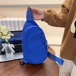 Detailed side view of a vibrant blue nylon casual crossbody chest bag on a desk.