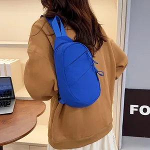 Back view of a vibrant blue nylon chest bag worn over a casual sweatshirt lifestyle shot