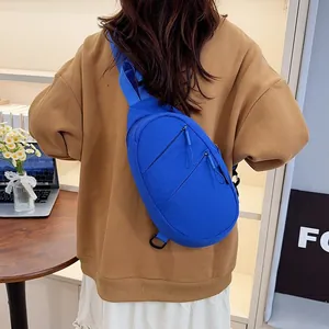 Back view of a minimalist blue nylon crossbody chest bag worn for daily casual commute.
