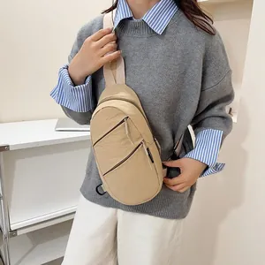 Close-up detail of a minimalist beige nylon chest bag worn by a model for lifestyle