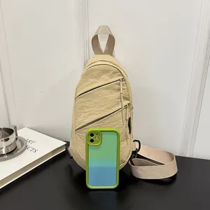 Versatile nylon chest bag shown for size comparison next to a smartphone on a desk.