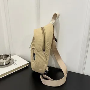 Close-up of beige nylon casual chest bag with adjustable strap and zipper details
