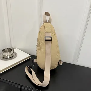 Back view detail of khaki nylon sling bag showing adjustable strap and texture