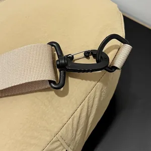 Close-up of the durable black swivel hook and strap detail on a khaki nylon chest bag