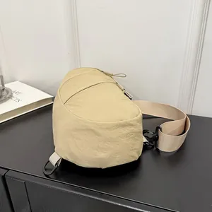 Side view of beige nylon minimalist chest bag showing material texture and strap detail