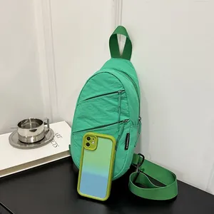 Detailed view of a green nylon sling bag paired with a matching gradient phone case