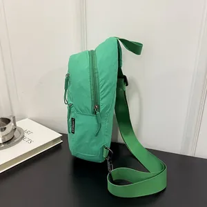 Detailed side view of a green nylon casual chest bag with adjustable strap and zip