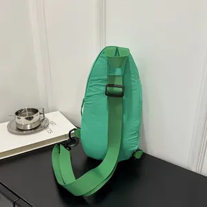 Detailed rear view of the green nylon chest bag showing the strap and clip design.