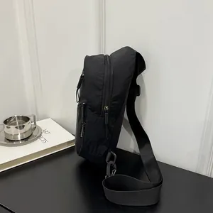 Side view of black nylon chest bag showing zipper detail and textured minimalist design