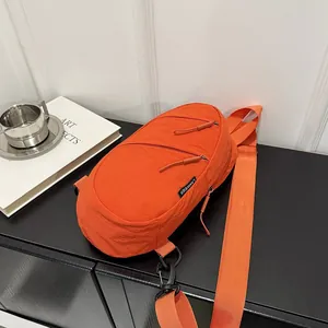 Close-up of a vibrant orange nylon sports chest bag in a minimalist lifestyle setting