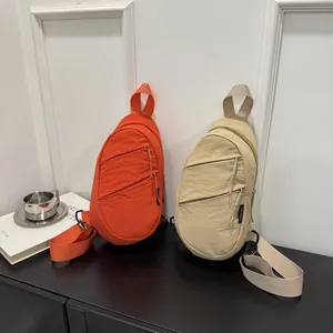 Detailed view of minimalist nylon sling bags in orange and beige for daily commute