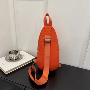Close-up back view of an orange nylon chest bag showing the texture and adjustable strap.