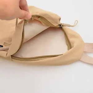Close-up of the smooth zipper and spacious interior lining of the khaki nylon bag.