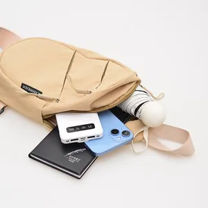 Close-up detail of the khaki nylon chest bag showing large capacity for daily essentials.