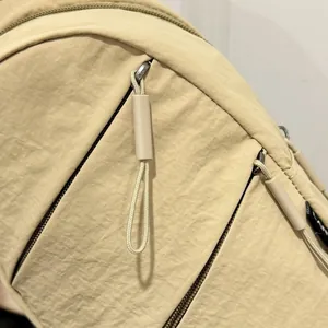 Close-up of nylon chest bag detailing zipper pullers and durable fabric texture