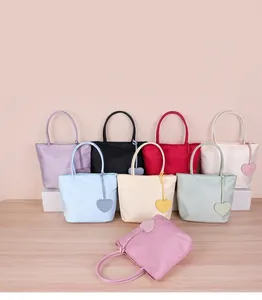 High-quality detailed view of colorful nylon tote bags with heart charms in various shades.