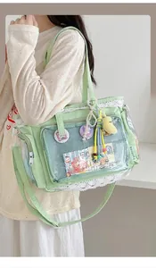 Detail der hellgrünen Ita-Tasche mit transparentem Fenster und weißem Spitzenbesatz-Design