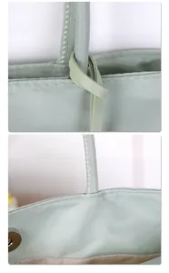 Close-up detail of handle stitching and fabric texture on a light green nylon tote bag