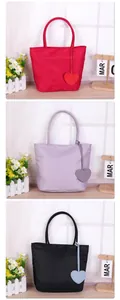 Detail view of minimalist nylon tote bags in red, purple and black with heart charms