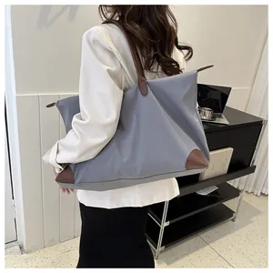 Detail view of the large capacity nylon travel tote bag with brown leather handles