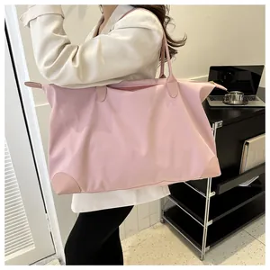 Bolso de viaje rosa de gran capacidad mostrado por una modelo en una oficina moderna.