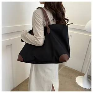 Large capacity black nylon travel tote bag shown on model's shoulder for commuter use