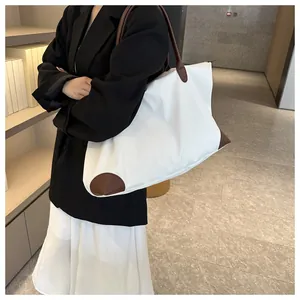 Asian model carrying a large white travel tote bag with brown leather details in an office