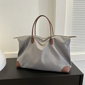Large grey nylon travel tote bag with brown handles for commuting and trips