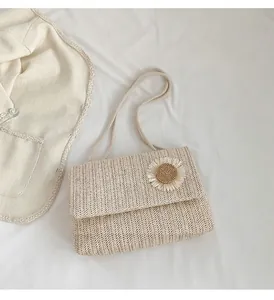 Vista de detalle de un bolso de paja minimalista con una flor tejida decorativa