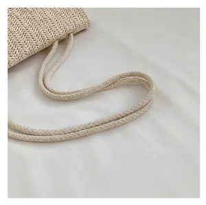 Primer plano detallado del asa de cuerda trenzada de este bolso de paja natural