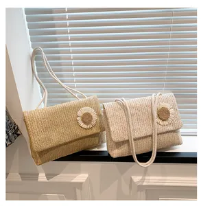 Bolsos de paja trenzados en caqui y crema con detalles de margaritas junto a una ventana